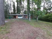 Charming single story home with a brick facade and covered parking nestled in a wooded lot at 3252 Pinehill Dr, Decatur, GA 30032