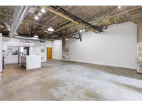 Bright living room featuring modern kitchen, industrial ceiling, and concrete floors at 505 Whitehall Sw St # 102, Atlanta, GA 30303