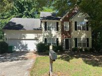 Traditional two-story home featuring a two-car garage, well-maintained lawn, and mature trees at 2581 Star Ln, Decatur, GA 30034