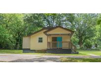 Charming single-story home with a cozy front porch and a bright blue front door at 525 Baker Nw Cir, Atlanta, GA 30318