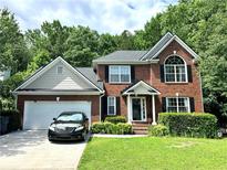 Charming brick home with a well-manicured lawn, a two-car garage and manicured front yard at 627 Arbour Way, Suwanee, GA 30024