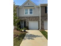 Charming townhome exterior with a well-manicured lawn and attached one car garage and brick and siding details at 536 Magnolia Cir # 116, Palmetto, GA 30268