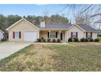 Charming single-story home with a well-manicured lawn and a cozy front porch at 130 Nicki Ct, Hampton, GA 30228