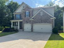 Beautiful two-story home featuring a stone and siding exterior, two-car garage, and a well-manicured front yard at 204 Starwood Ct, Acworth, GA 30102