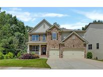 Traditional two-story home with a brick and stone facade and a well-manicured lawn with mature trees in the background at 204 Starwood Ct, Acworth, GA 30102