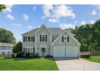 Charming two-story home with a well-manicured lawn and attached two-car garage at 7025 Coffield Ct, Cumming, GA 30041