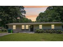 Charming single-story home with a well-manicured lawn, garden, and welcoming front entrance at 905 Scott Sw Ln, Marietta, GA 30008