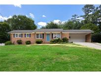 Charming brick home with a well-maintained lawn and blue door on a sunny day at 4172 N Martin Way, Lithia Springs, GA 30122