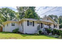 Charming home with a welcoming front porch and lush green lawn at 3215 Woodview Se Dr, Smyrna, GA 30082
