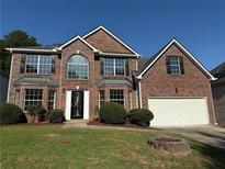 Traditional brick home with manicured lawn, bay windows, and two-car garage at 7097 Cavender Sw Dr, Atlanta, GA 30331