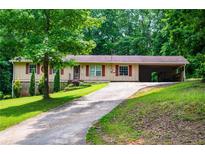 Charming single-story home featuring red accents, attached carport, and a well-maintained front yard at 100 Eldorado Dr, Carrollton, GA 30116