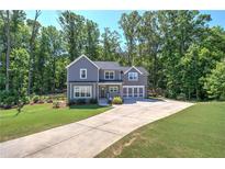 Charming two-story home features a well-manicured lawn, attached garage and lush, mature trees at 194 Saddleridge Dr, Bremen, GA 30110