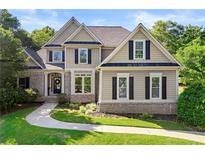 Charming two-story home with well-manicured lawn, brick accents, and inviting entrance at 4440 Green Summers Dr, Cumming, GA 30028