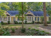 Charming ranch home with beautiful landscaping, blue shutters, and a welcoming entrance at 360 N Oakland Circle, Mcdonough, GA 30253