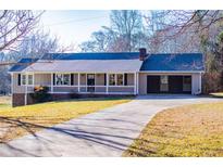 Charming single-story home featuring a covered porch, attached garage, and a well-maintained front yard at 280 Hitchcock Rd, Dallas, GA 30157