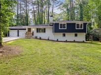 Charming home featuring a two-car garage, manicured lawn, and mature trees at 466 Thackery Sw Pl, Atlanta, GA 30311