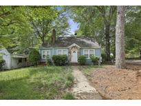 Charming single-story home with a stone accented front door and an unkept front yard at 1864 Madrona Nw St, Atlanta, GA 30318