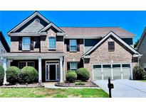Charming two-story brick home featuring a two-car garage and manicured landscaping at 3476 Bridge Walk Drive, Lawrenceville, GA 30044