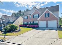 Charming brick home with two-car garage and well-maintained landscaping at 665 Roxford Ln, Buford, GA 30518