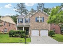 Charming two-story home with brick facade, blue shutters, two-car garage and a well-manicured lawn at 5937 Sharp Se Dr, Mableton, GA 30126