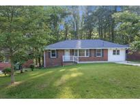 Charming brick home with a well-manicured lawn and mature trees, offering a peaceful and inviting curb appeal at 2773 Fairlane Dr, Atlanta, GA 30354