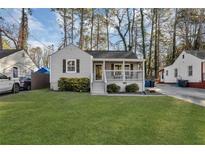 Charming home featuring a well-maintained front yard, a covered porch, and beautiful landscaping at 2912 Palm Dr, East Point, GA 30344