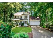 Charming two-story home with a well-manicured front yard and a two-car garage, surrounded by lush greenery at 404 Summerchase Way, Woodstock, GA 30189