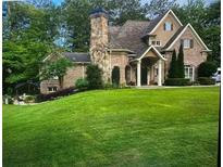 Charming two-story brick home with a manicured lawn and stone chimney at 5172 Roswell Rd, Marietta, GA 30062