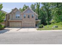 Charming townhome with a two-car garage, brick accents, and a well-manicured front lawn at 2333 White Oak Se Bnd, Smyrna, GA 30080