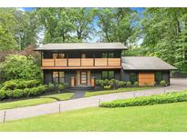Striking two-story home with a modern design, landscaped front yard, and a welcoming brick driveway at 4601 Tall Pines Nw Dr, Atlanta, GA 30327