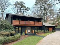 Beautiful black two-story home with a wooden balcony and well-maintained landscaping at 4601 Tall Pines Nw Dr, Atlanta, GA 30327