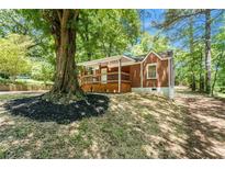 Charming brick home with a cozy front porch and a beautiful, large tree in the front yard at 2174 Rexford Dr, Decatur, GA 30034