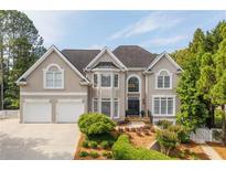 Charming two-story home features a manicured front lawn, two-car garage, and classic architectural details at 3495 Mill Bridge Dr, Marietta, GA 30062