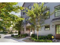 Attractive three story gray brick townhome with lush landscaping and trees lining the sidewalk at 126 Chestnut Cir, Atlanta, GA 30342