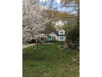 Charming home with manicured lawn, flowering trees, and a lovely teal front door at 136 Bucher Dr, Decatur, GA 30030