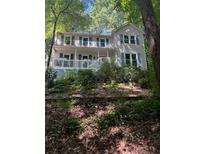 Charming two-story home with a welcoming front porch, surrounded by lush greenery and mature trees at 507 Spring Creek Ne Way, Marietta, GA 30068