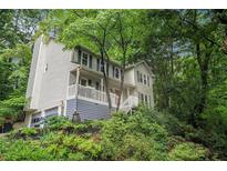 Charming two-story home with a covered front porch nestled among mature trees and lush landscaping at 507 Spring Creek Ne Way, Marietta, GA 30068
