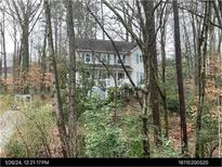 Two-story home with light blue shutters, surrounded by mature trees and lush greenery, offering a serene setting at 507 Spring Creek Ne Way, Marietta, GA 30068