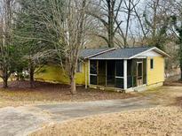 Charming single-story home featuring a cozy screened-in porch, mature trees and a paved driveway at 1101 Isa Se Dr, Atlanta, GA 30315