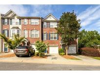 Charming brick townhome with well-maintained landscaping and attached garage on a sunny day at 3187 Mill Springs Cir, Buford, GA 30519