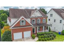 Charming two-story brick home with a covered porch, landscaped yard, and two-car garage at 5280 Lakerock Way, South Fulton, GA 30331
