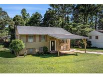 Charming home featuring a covered carport, mature trees, and a well-maintained front yard at 992 Brian Ln, Forest Park, GA 30297