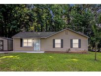 Charming single-story home features a well-maintained lawn and a convenient storage shed at 22 Cardinal Ln, Jonesboro, GA 30238
