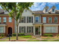 Charming townhome with a well-manicured lawn and a mix of brick and siding facade at 239 S Village Sq, Canton, GA 30115