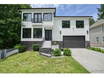 Stunning two-story white brick home with a black garage, modern black window frames, and beautiful landscaping at 2804 Skyland Ne Dr, Brookhaven, GA 30341