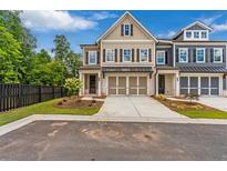 Charming two-story townhome with a neutral color palette, attached two-car garage, and well-manicured landscaping at 206 Grady Burrell Dr, Holly Springs, GA 30115
