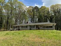 Charming single-story home with a covered front porch nestled amongst mature trees on a spacious lawn at 3195 Sw Panther Sw Trl, Atlanta, GA 30311