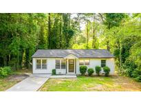 Charming single story home with neutral paint, manicured shrubs, and a lovely walkway leading to the front door at 398 Baker Nw Cir, Atlanta, GA 30318