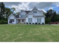 Charming two-story home with white siding, grey shutters, and a well-manicured front lawn at 605 Red Leaf Way, Canton, GA 30114