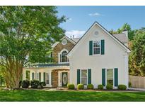 Charming two-story home featuring stone accents, a covered porch, and lush green landscaping at 1093 Forest View Sw Ln, Lilburn, GA 30047